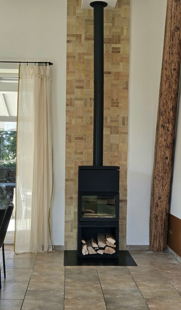 Mur en Bejmat terre cuite artisanale derrière un poêle à bois – idée déco authentique et naturelle
