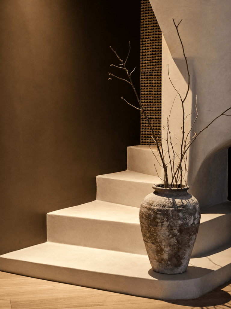Rénovation intérieure d'une maison avec escalier en béton ciré réalisé par une décoratrice d'intérieur spécialisée en conception globale.